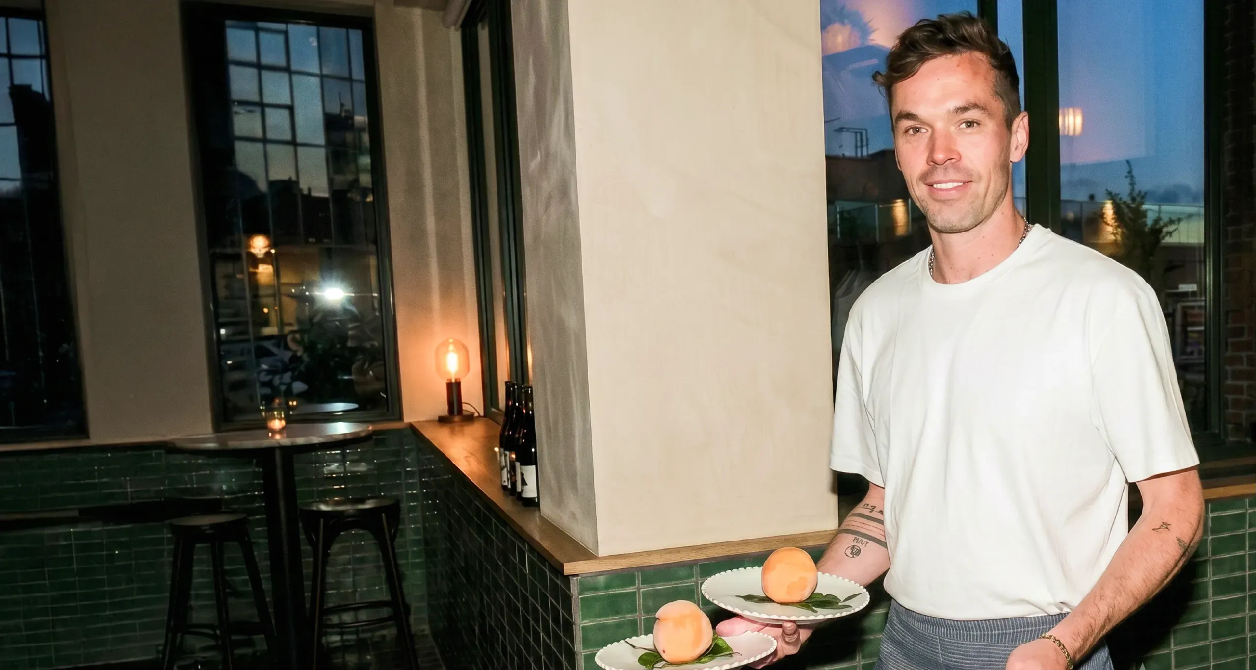 Traiteur qui présente une assiette dans une salle éclairée à la bougie